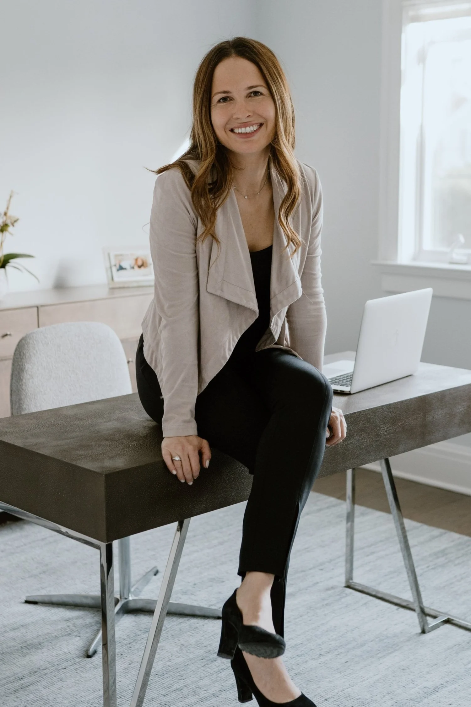 Dara Astmann sitting beside a window in her workspace